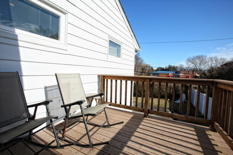 Modern sun deck in Surrey with wooden flooring and outdoor seating.