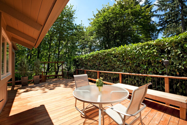 Surrey backyard sun deck with comfortable lounge chairs and potted plants.